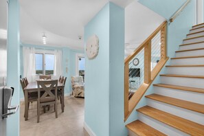 A modern interior with a dining area, a staircase, and a view of the outdoors. - Oceanfront Pinnacle Port condo with tennis & basketball courts, private balcony (Panama City Beach)