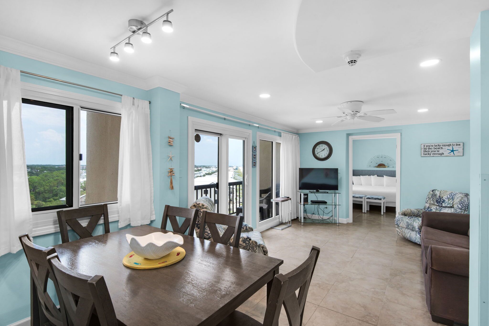 A spacious living area with a dining table, chairs, a sofa, and a TV.