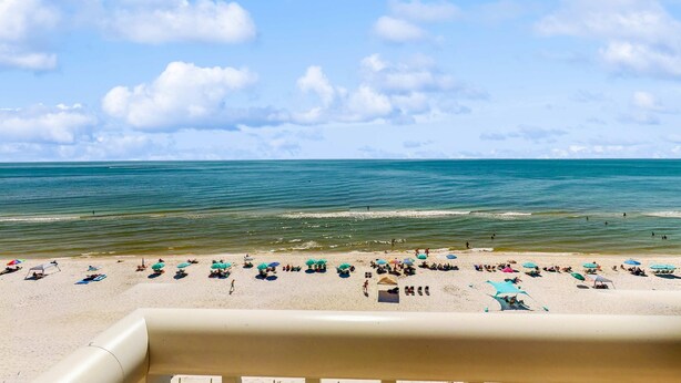 Ein Strand mit Sonnenschirmen und Menschen.