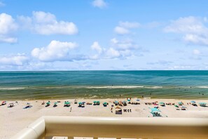 Ein Strand mit Sonnenschirmen und Menschen.