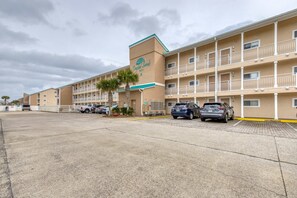A hotel with a central entrance, multiple balconies, and a parking lot. - Stunning third-floor condo with balcony, washer&dryer & pool (Destin)