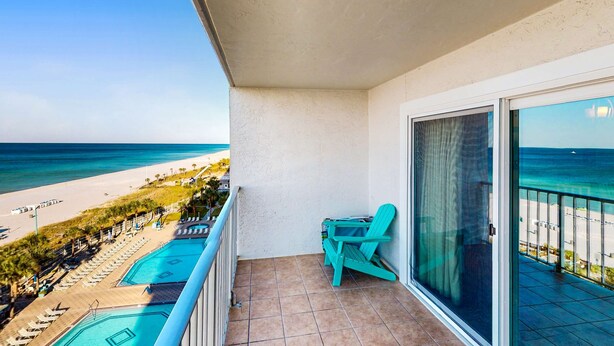 A balcony with a view of the beach and a pool. - Gulf-front condo with balcony, W/D, direct beach access, pools, hot tub & gym (Panama City Beach)
