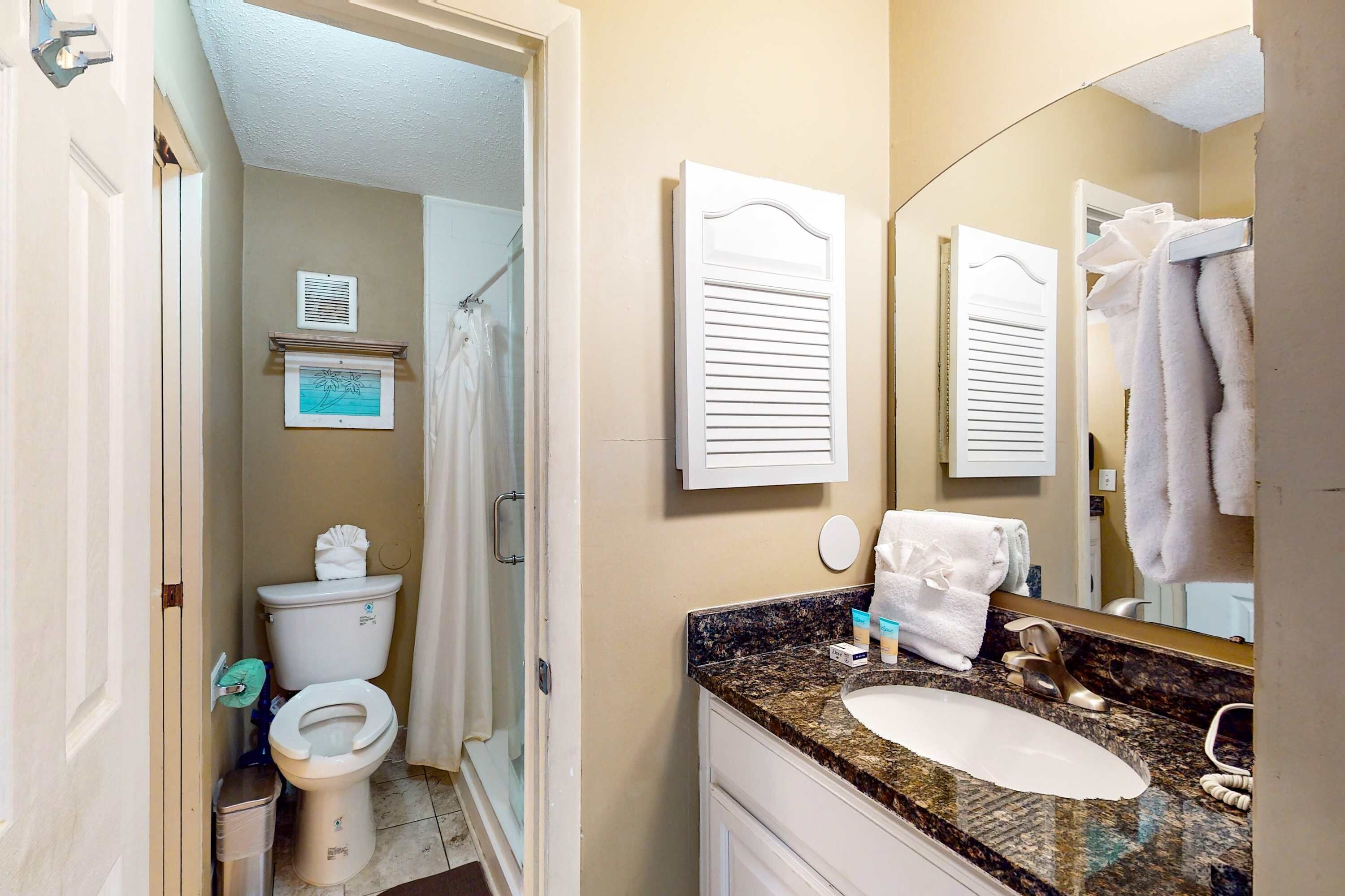 A bathroom with a toilet, sink, and shower.