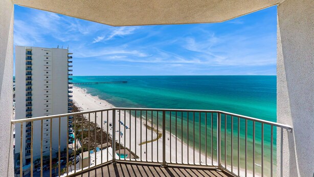 A balcony with a view of a beach and ocean. - High-rise condo at beachfront resort w/ pools, hot tubs & arcade (Panama City Beach)