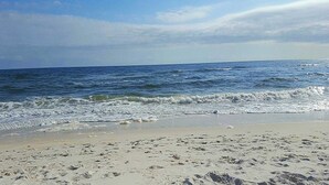 A beach with visible footprints in the sand and waves approaching the shore. - Gorgeous townhouse, plenty of space, lots of games, shared pool, close to beach (Perdido Key)