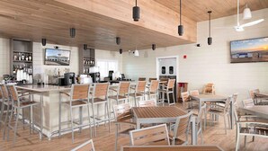 A modern restaurant with a bar area, multiple seating arrangements, and a large painting on the wall. - Gorgeous townhouse, plenty of space, lots of games, shared pool, close to beach (Perdido Key)