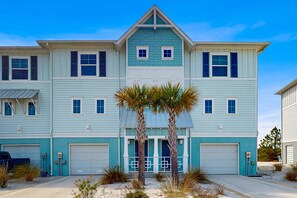 A two-story house with a garage, a front porch, and a driveway.