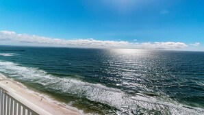 Ein Strand mit Wellen und blauem Himmel.