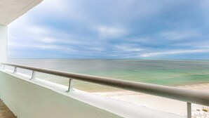 A balcony with a view of a beach and ocean.