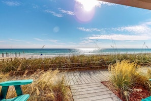 A wooden boardwalk leading to a beach with a clear view of the ocean and fishing rods in the distance. - Oceanfront Condo w/ AC, WiFi, Shared Pool, & Seasonal Beach Service Rentals (Destin)
