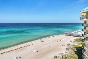 A beachfront hotel with a sandy beach, a pool, and a view of the ocean. - Beachfront retreat with a balcony, great views, tennis, pools & gym (Panama City Beach)