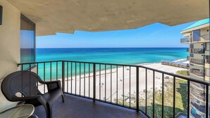 Ein Balkon mit Blick auf Strand und Meer.