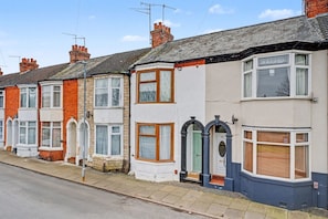 A row of terraced houses with distinct front doors, each with a different color and architectural style.