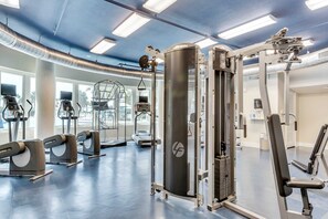 A gym with various exercise equipment, including treadmills, ellipticals, and weight machines. - Warm, Welcoming Condo At Waterscape w Children's Playground & Two Hot Tubs (Fort Walton Beach)