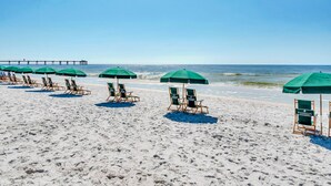 A beach with rows of green umbrellas and beach chairs. - Bright, beachy condo At Waterscape w children's playground, 2 hot tubs (Fort Walton Beach)