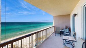 A balcony with a view of the ocean, a table, and two chairs. - Elegant & spacious condo with incredible Gulf-front views, two pools & gym (Panama City Beach)