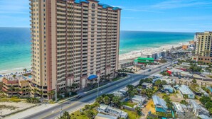 A high-rise hotel with multiple floors, a beach view, and a road leading to the beach. - Welcoming waterfront condo with a furnished balcony, pool & pool spa (Panama City Beach)