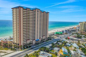 A high-rise hotel with multiple floors, a beach view, and a road leading to the beach. - Welcoming waterfront condo with a furnished balcony, pool & pool spa (Panama City Beach)