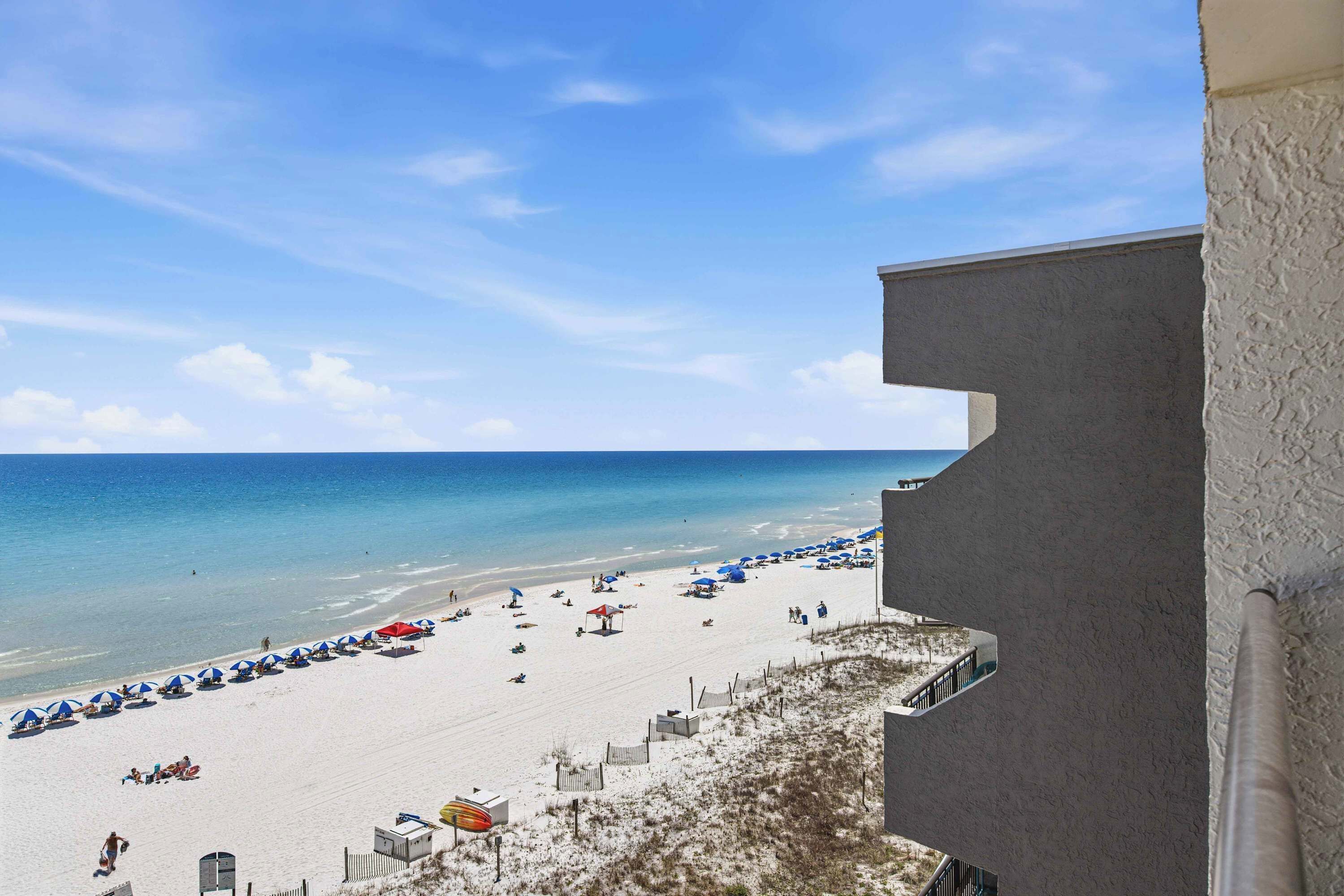 Ein Strand mit Sonnenschirmen und blauem Himmel.