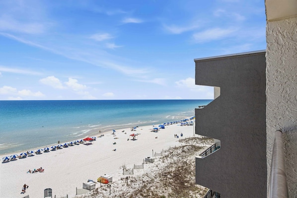 A beach with umbrellas and a clear sky. - Updated beachfront condo with beach setup - quick drive to entertainment (Fort Walton Beach)
