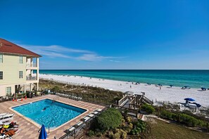 A pool area with a view of the beach and ocean. - Large, updated condo - quick walk to beach & convenient to shopping (Miramar Beach)