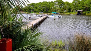 A dock with boats, surrounded by greenery and a small pavilion. - Condo close to the beach with pools, dock & tennis - snowbird-friendly (Panama City Beach)