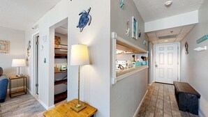 Een gang met een houten bankje, een lamp en een deur naar een keuken.