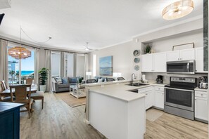 A modern apartment with a kitchen, dining area, and living room. - Beautiful 2nd-floor condo in Seagrove Beach with beach ambience & pickleball (Santa Rosa Beach)
