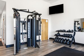 A gym with a pull-up bar, weight stack, and dumbbells. - Beautiful 2nd-floor condo in Seagrove Beach with beach ambience & pickleball (Santa Rosa Beach)