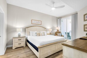 A bedroom with a bed, nightstands, a desk, and a ceiling fan. - Beautiful 2nd-floor condo in Seagrove Beach with beach ambience & pickleball (Santa Rosa Beach)