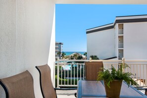 Un balcon avec vue sur l’océan, une piscine et un immeuble doté de balcons.