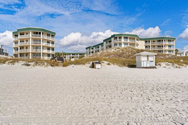 A beachfront hotel with multiple balconies, a lifeguard tower, and sandy beach. - 3rd-floor condo with sauna, gym, pool, tennis & pickleball, conference room (Santa Rosa Beach)
