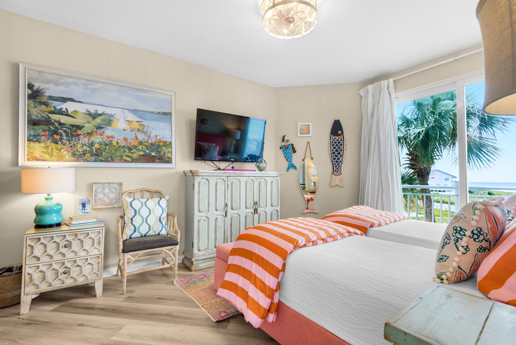 A bedroom with a bed, a chair, a TV, and a painting on the wall.
