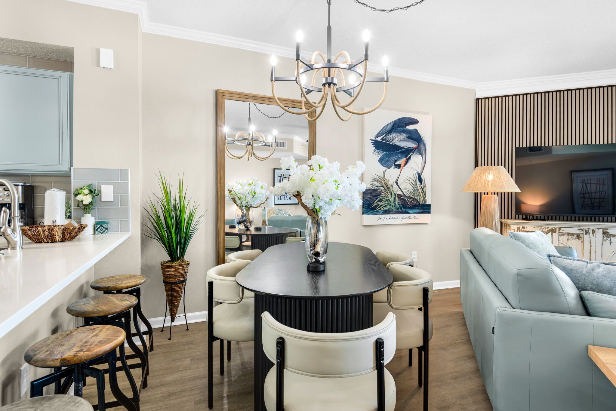 Ein modernes Wohnzimmer mit Essbereich, einer Couch und einem Chandelier.