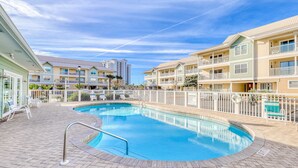 A swimming pool with a brick deck, surrounded by multi-story buildings with balconies. - Ground-floor condo half block from the beach with patio, central AC, pool & WiFi (Destin)
