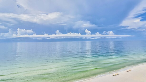 A beach with clear turquoise water and a sandy shore. - Ground-floor condo half block from the beach with patio, central AC, pool & WiFi (Destin)