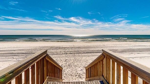 A wooden beach boardwalk leading to a sandy beach with ocean waves. - Modern oceanfront studio with pool access, central AC, and beach service (Fort Walton Beach)