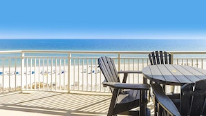 Een terras met uitzicht op de oceaan, met een tafel en stoelen.