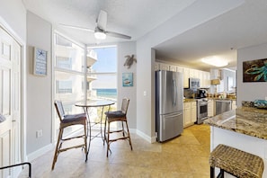 A modern kitchen with a large island, stainless steel appliances, and a view of the ocean. - Fifth-Floor, Gulf-Front Condo w/ Balcony, Beach Access & Shared Pools/Hot Tub (Perdido Key)