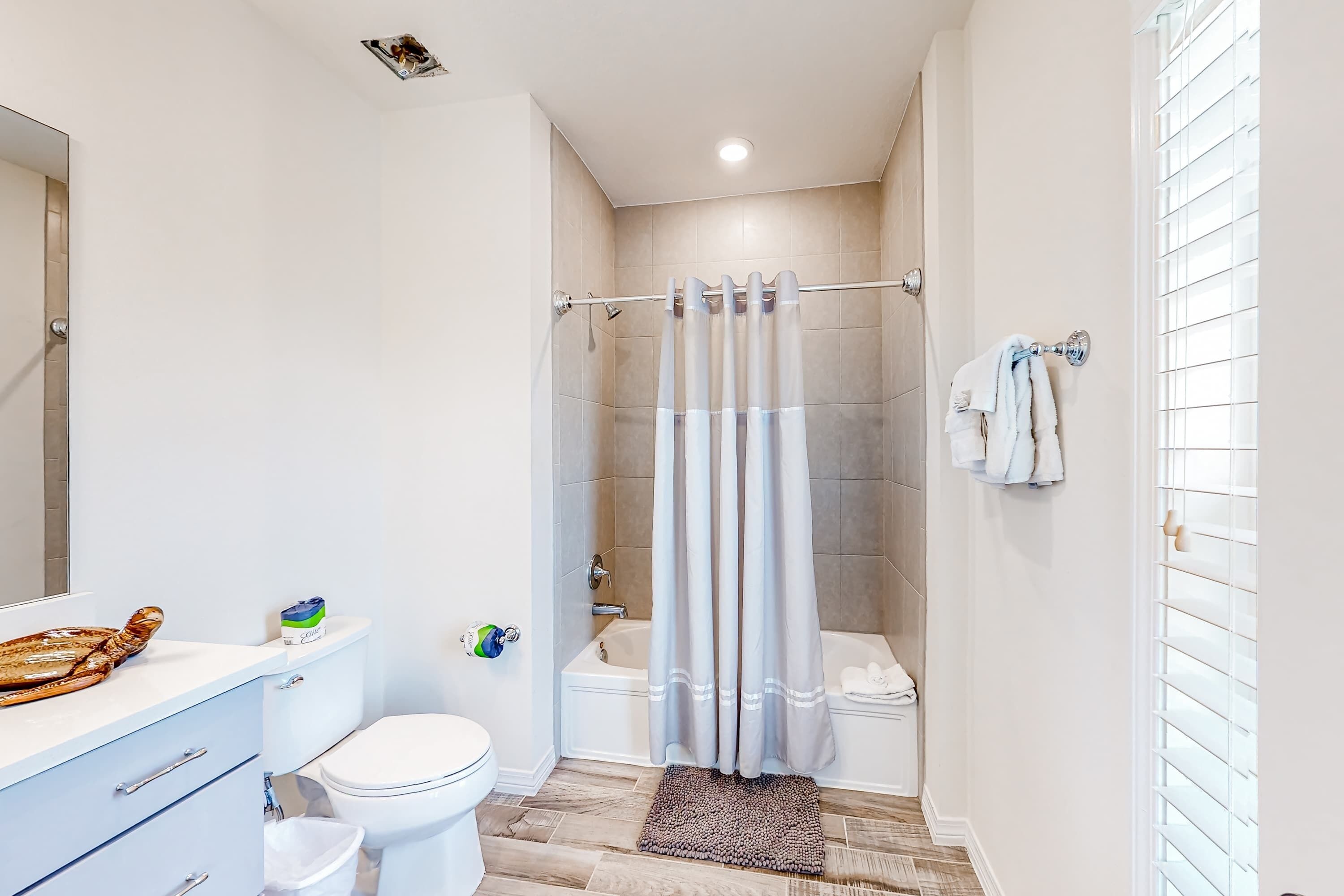 A modern bathroom with a shower, toilet, and sink.