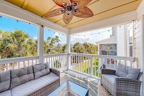 A covered porch with wicker furniture and a ceiling fan. - Dog-friendly townhouse with private beach, hot tub, pool, tennis, golf, gym, AC (Perdido Key)