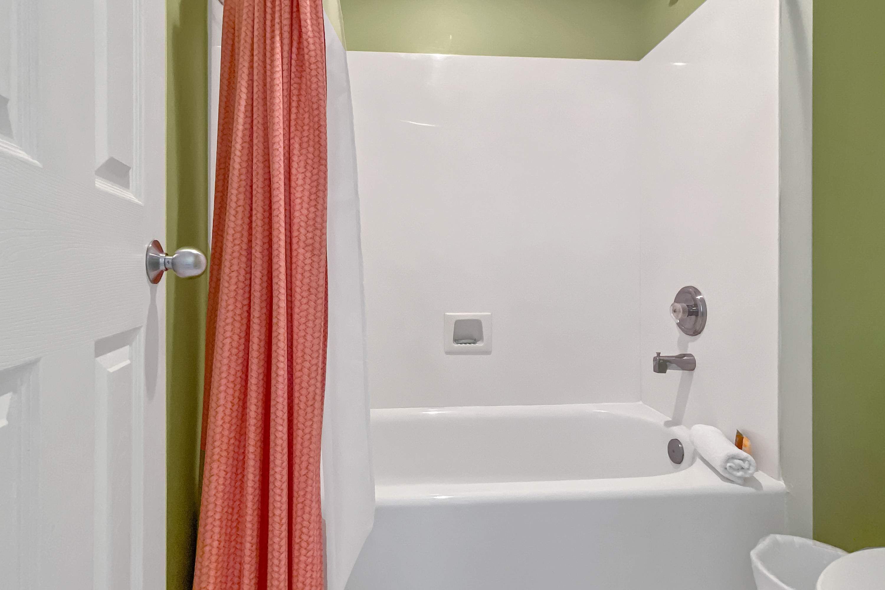 Une salle de bain avec une baignoire blanche, une serviette et des toilettes.