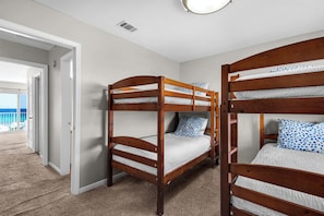 A room with bunk beds, carpeted flooring, a door leading to a balcony, and a ceiling vent. - 2-story condo with Gulf views, on-site pool, balconies, & easy beach access (Panama City Beach)