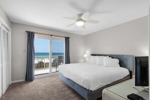 A hotel room with a bed, a desk, a television, a ceiling fan, and a view of the ocean. - 2-story condo with Gulf views, on-site pool, balconies, & easy beach access (Panama City Beach)