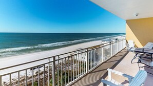 Ein Balkon mit Blick auf Strand und Meer.