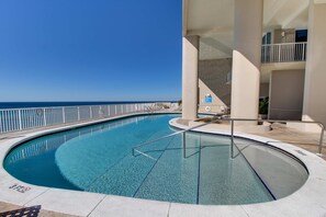 A swimming pool with a clear view of the ocean, a metal railing, and a staircase leading to an upper level. - Nautical getaway just steps from the beach with pool & hot tub (Panama City Beach)