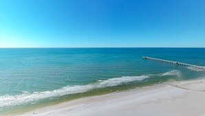 Ein Strand mit einem Steg, der sich ins Meer erstreckt.