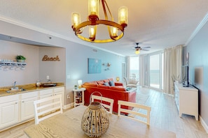 Ein modernes Wohnzimmer mit einem roten Sofa, einem Holzesstisch und einer Chandelüster.
