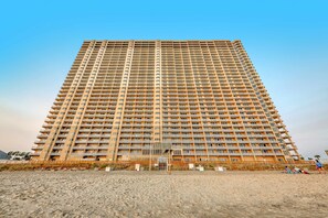Et højt, mangeetagers hotel med ensartet facade, balkoner og en indgang i stueplan.