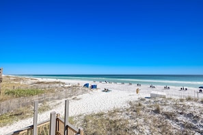 A beach with a wooden fence, beach chairs, and umbrellas. - Gorgeous coastal private home, close to everything and shared pool (Miramar Beach)